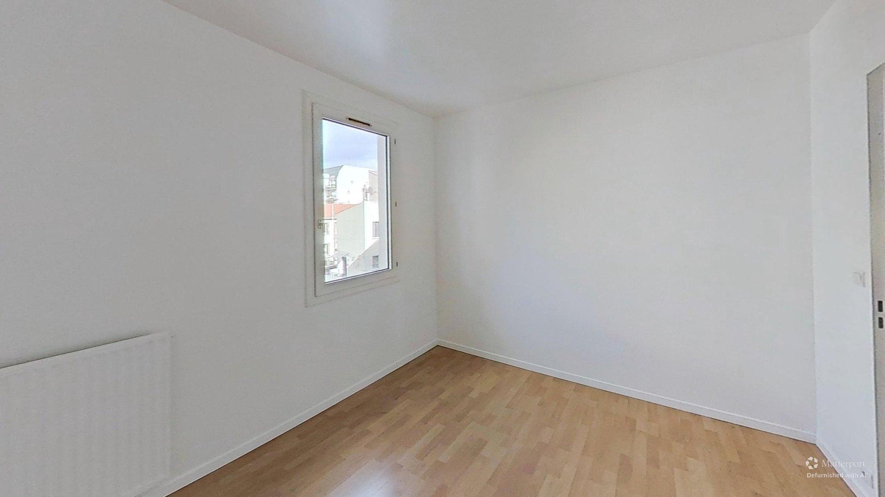Chambre de l'appartement avec parquet flottant et radiateur